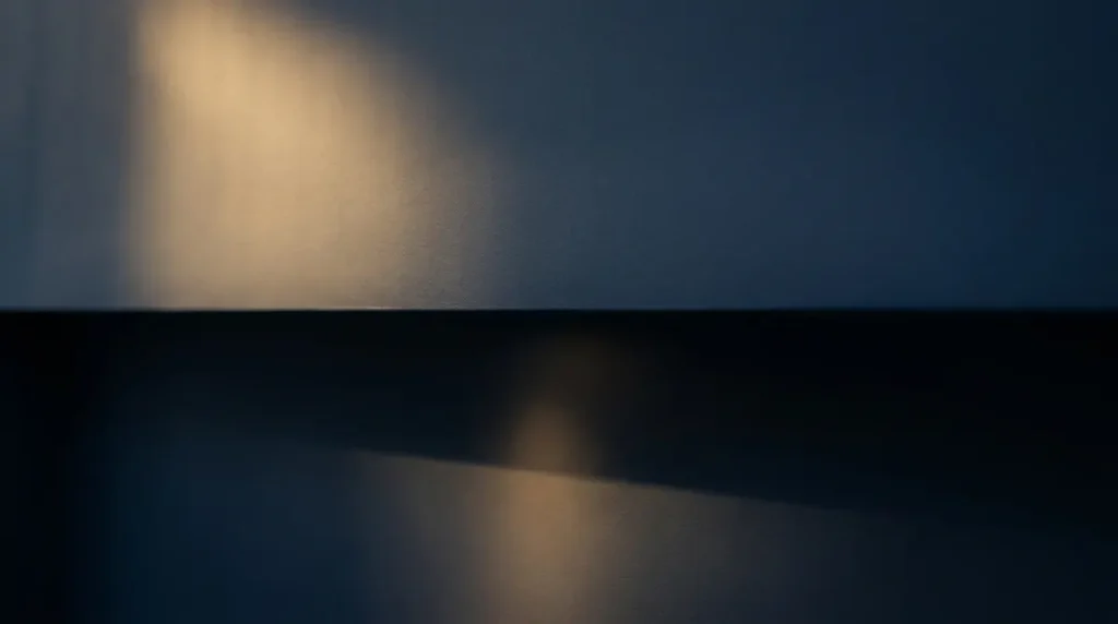 Wand mit klarer waagerechter Linie zwischen Licht und Schatten